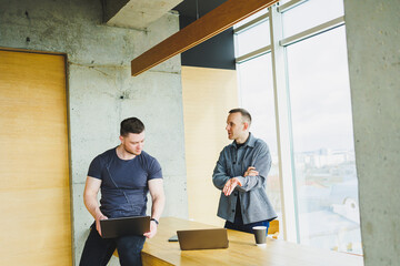 Young team of colleagues working together in office listening to manager during business meeting and working together on project launch in modern conference room