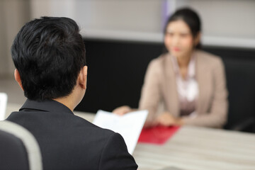 Fototapeta premium Human resources department managers sitting and interviewing female businesswoman applicant or candidate during job interview in modern office (Focus on female candidate). Business recruitment concept