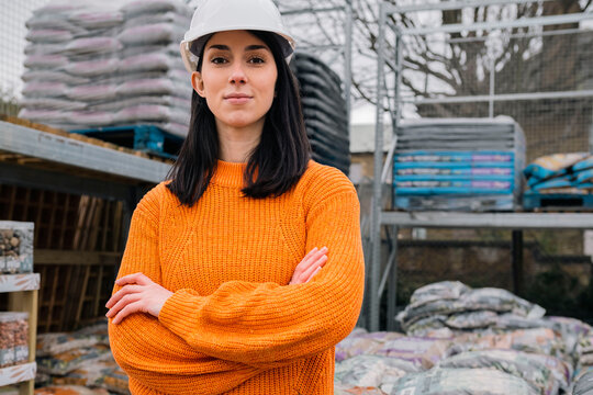 Confident Young Woman Standing With Arms Crossed At Construction Site