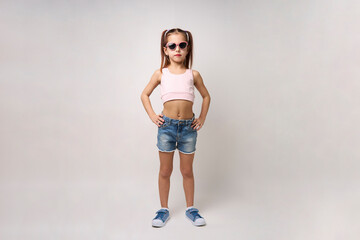 Cute little girl wearing denim shorts and top, white background