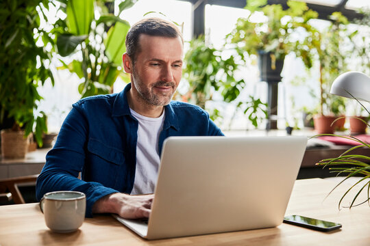 Businessman surfing net on laptop at loft office