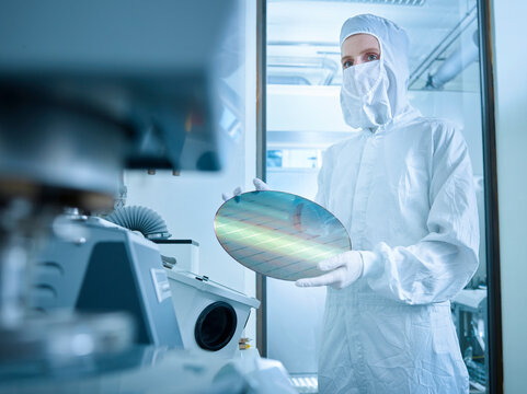 Engineer holding wafer chip in laboratory