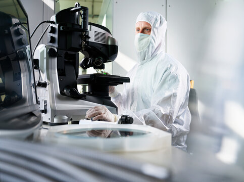 Technician using microscope working in laboratory