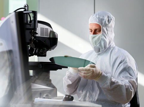Engineer putting wafer chip on microscope in laboratory
