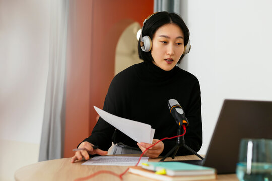 Woman wearing headset recording podcast in podcast studio