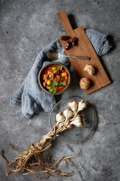 Studio shot of bowl of ready-to-eat North African stew with pumpkin, chickpeas, lentils, dates, cilantro and garlic