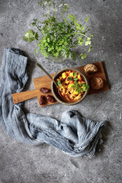 Studio shot of bowl of ready-to-eat North African stew with pumpkin, chickpeas, lentils, dates and cilantro