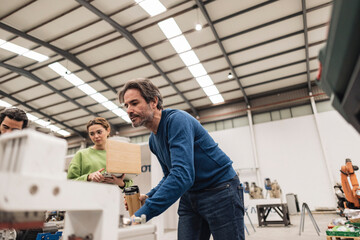 Mature engineer with colleagues in factory