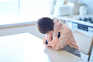 ストレスを抱えた表情をするエプロン姿の女性