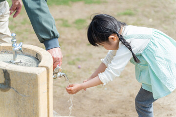 公園の水道で手を洗う子供（育児・子育て）
