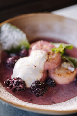 Curd fritters in cream-berry sauce with bilberry. Cheesecake decorated sour cream and mint.