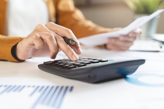 person using calculator calculating tax refund on the table