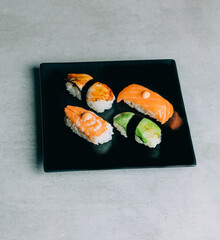 traditional sushi with salmon, eel and tuna on black plate