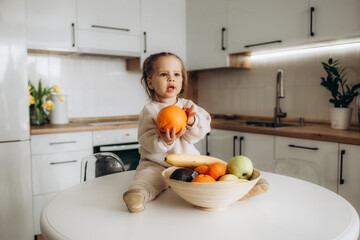 Portrait of a little girl with sweet pepper. Playing in the kitchen.