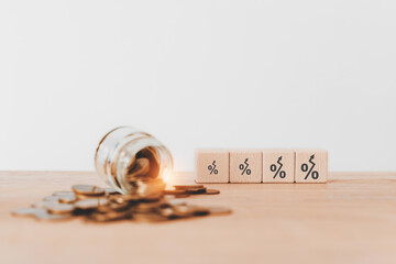 For business and finance background, growth  interest, income, profit concept. Wooden cube blocks with percentage icon and blurred coins including copy space