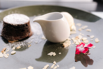 Obraz na płótnie Canvas Chocolate fondant with scoop of ice cream, blackberry syrup and slices of almond 