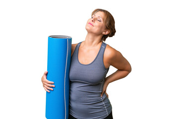 Middle-aged sport woman going to yoga classes while holding a mat over isolated background...