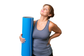Middle-aged sport woman going to yoga classes while holding a mat over isolated background suffering from backache for having made an effort
