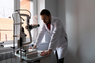 Doctor examining eye scanner machine at clinic