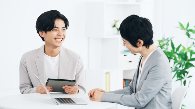 オフィスで会話するビジネスパーソン