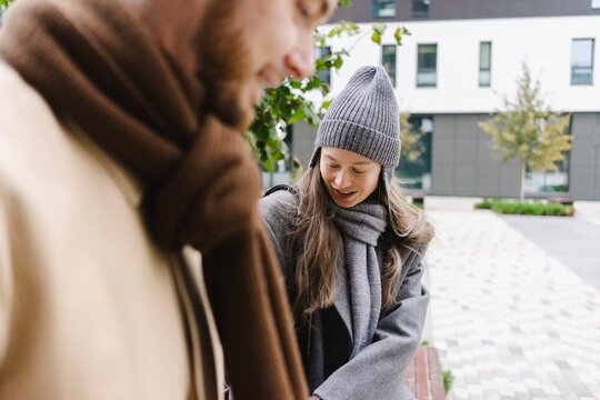 Smiling woman wearing knit hat near man