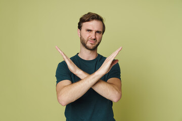 Man showing denial gesture isolated over green background