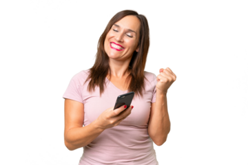 Middle-aged caucasian woman over isolated background with phone in victory position