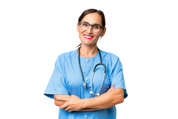 Middle-aged nurse woman over isolated background keeping the arms crossed in frontal position