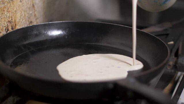 Pouring mix on plate making Enjera Yemeni style Ethiopian pan cooking