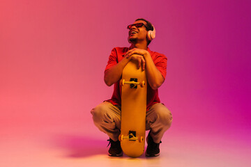 African guy posing with skateboard isolated over gradient neon background