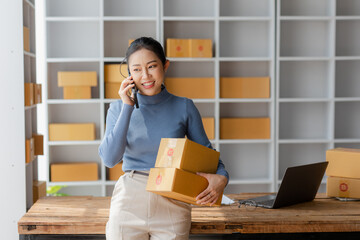 Startup, small business, SME, Asian female entrepreneur owner uses smartphones to talk to customers online and check online orders to prepare packages. Sell Ideas Online.