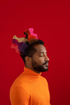 Young man with colorful pick combs against red background