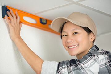 woman with level measurement at the wall