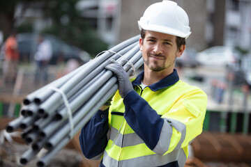 construction worker on site holding pipe