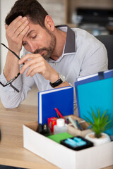 fired depressed businessman with box at his desk