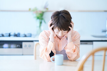 頭痛に苦しむエプロン姿の女性