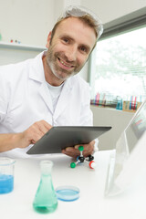 portrait of smiling worker using digital tablet in lab