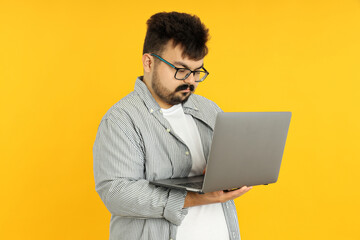 Concept of people, young fat man with laptop on yellow background