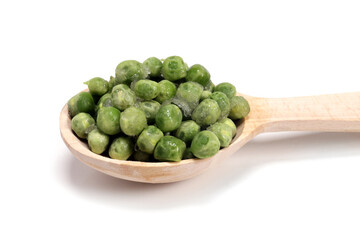 Frozen green peas in wooden spoon isolated on white