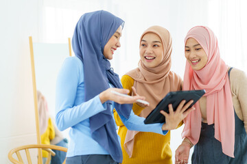 Group of a beautiful smart Asian muslim woman standing in the room and having a discussion together.