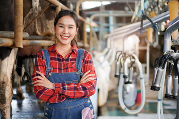 Professional Asian female animal husbandry working in dairy milk farm.