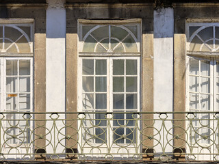 Typical Portuguese houses, covered with colorful azulejos, in the historic part of the city of Porto, Portugal. Details of house facades, windows, balconies, railings, colored ceramics.