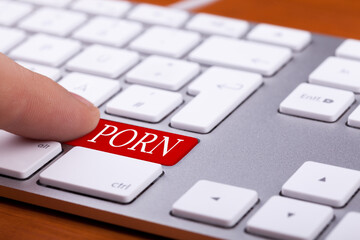 Finger pressing on red button with porn word on it. Sex and xxx sites. Adult content only