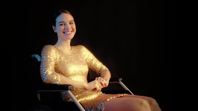 Portrait of happy young woman with disability wearing prom dress in wheelchair
