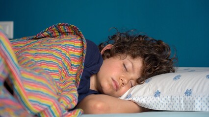 Boy child 8 years old sleeping at home in bedroom apartment - lifestyle in childhood - sleep in...