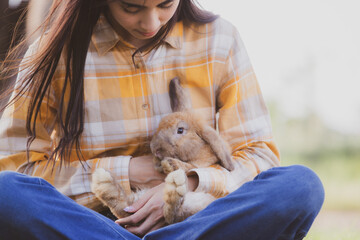 relationships of cheerful rabbit and happy young human girl, Asian woman holding and carrying cute...