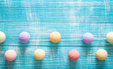 Multicolored bath bombs on a blue wooden background, top view.