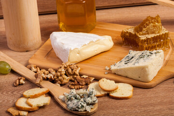 Dor blue and white cheese with nuts and honey on vintage wooden background in studio photo
