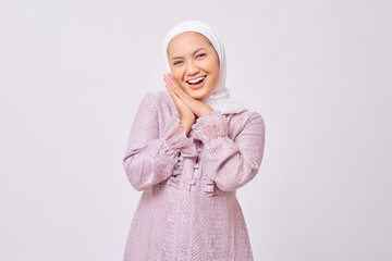 Portrait of cheerful beautiful young Asian Muslim woman wearing hijab and purple dress  pressing...