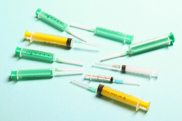 Top view of medical syringes with needles at blue background with copy space. Injection treatment concept